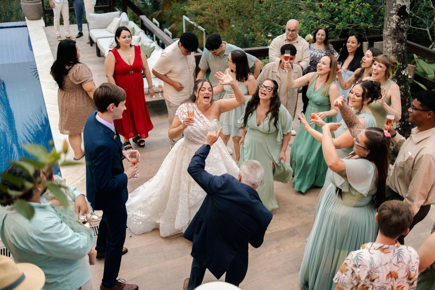 Wedding guests dancing and celebrating at an outdoor reception.