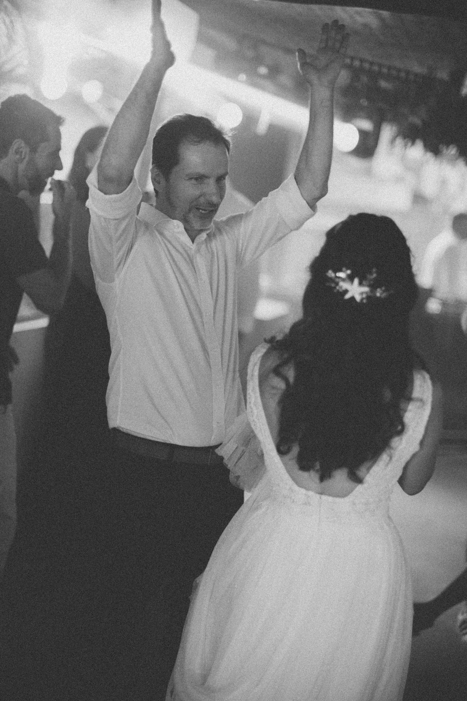 Black and white photo of dancers twirling on a dimly lit dance floor.
