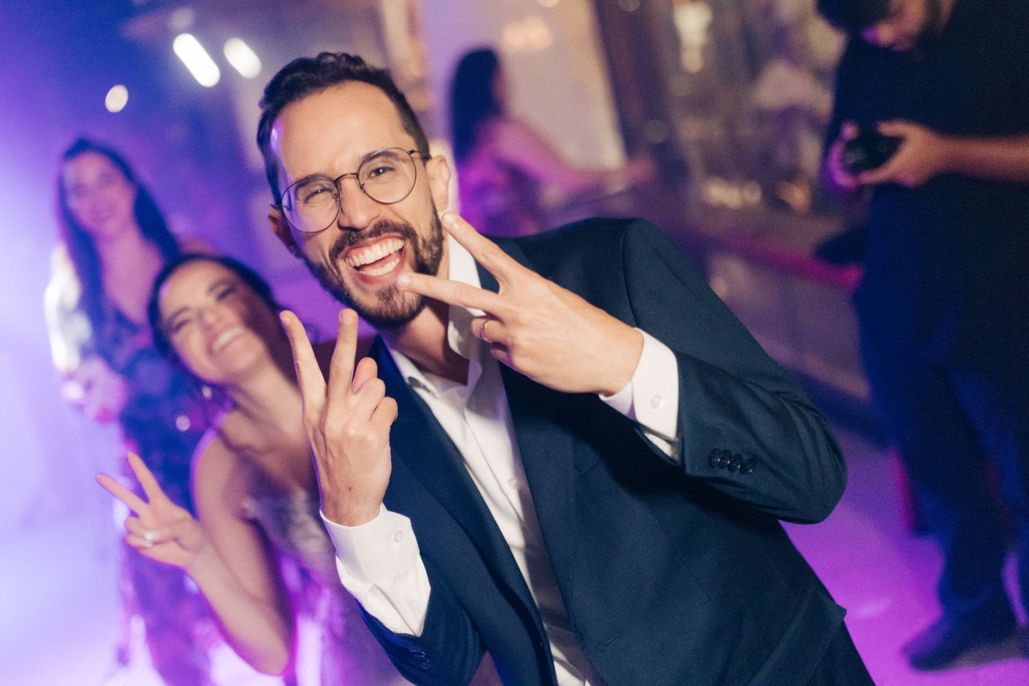 Wedding reception dance party with purple and pink mood lighting.