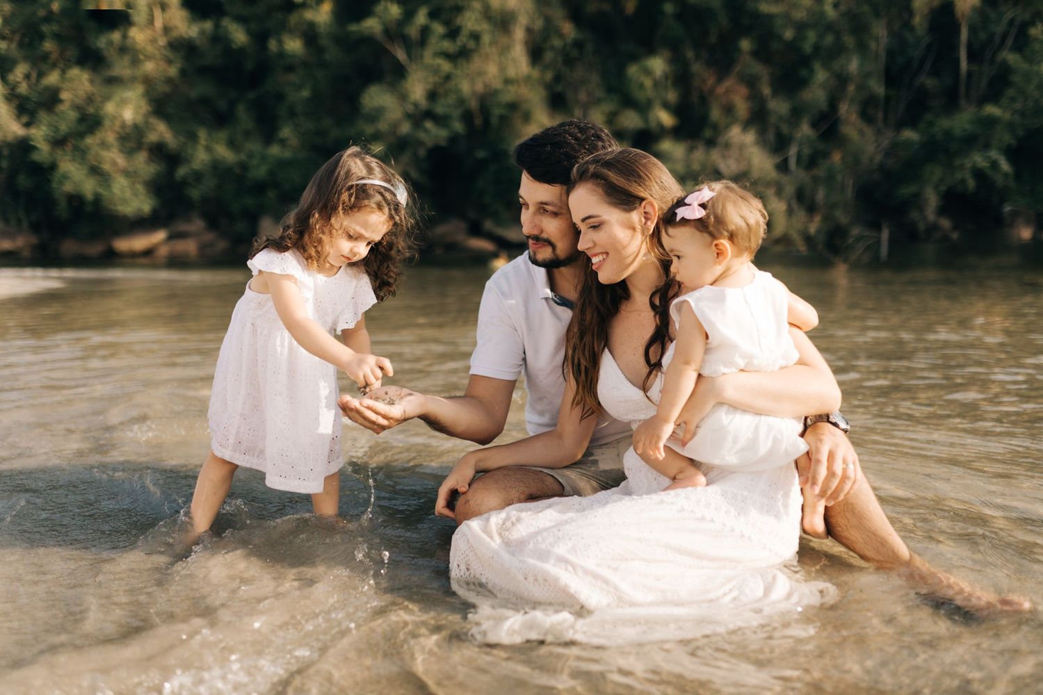 Sweet family interaction while sitting in shallow beach water.