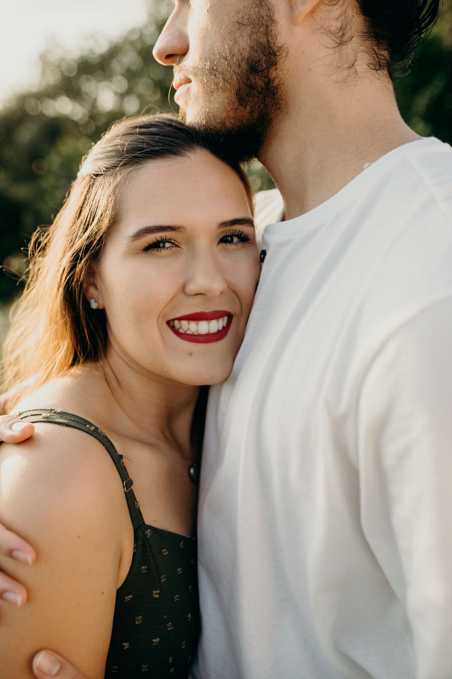 Intimate close-up portrait of couple in casual attire during sunset engagement session.