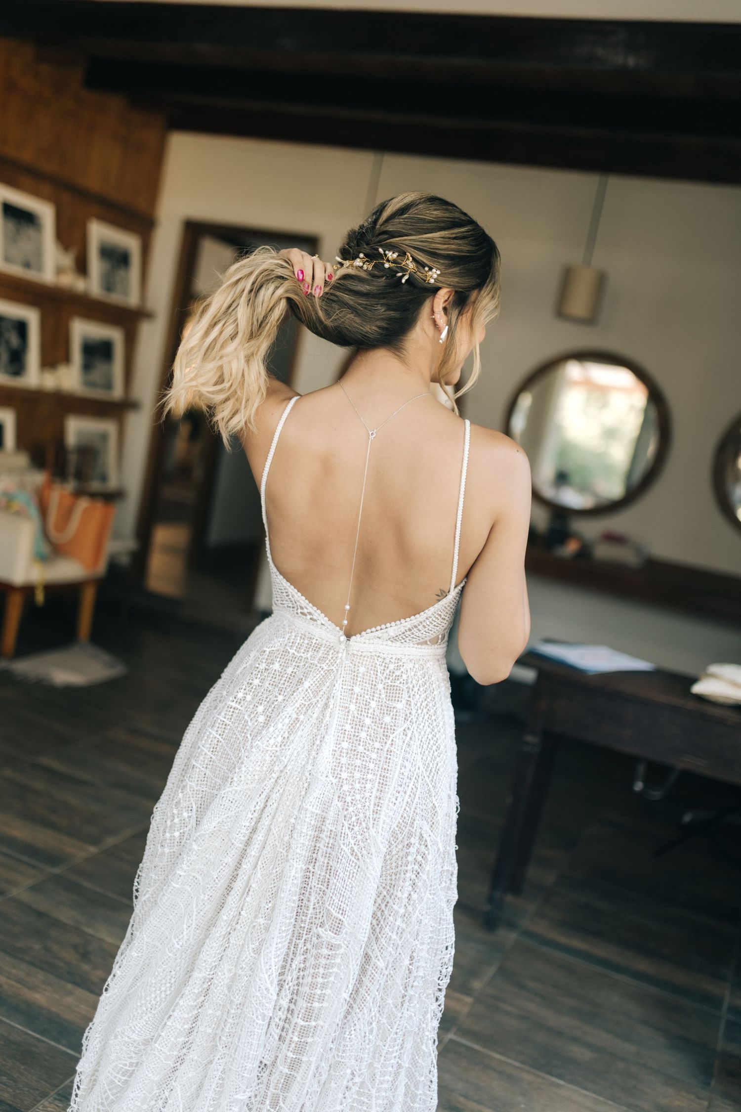 Back view of white lace dress showing delicate strap details and flowing fabric.