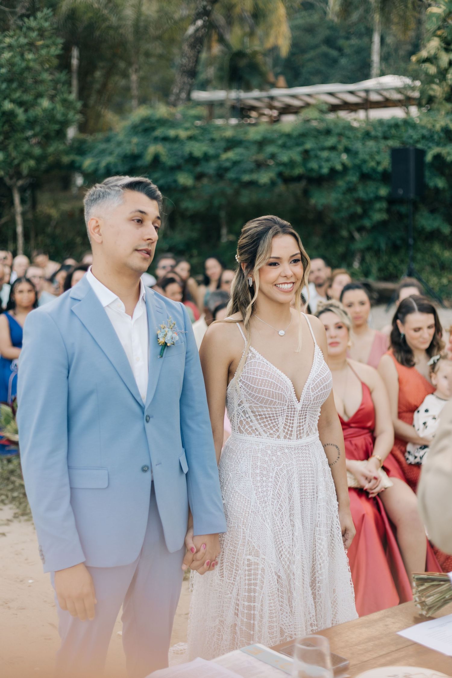 Wedding party standing together during an outdoor garden ceremony.