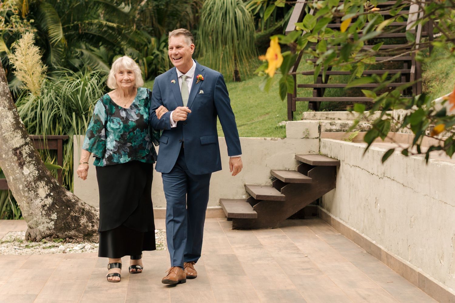 Outdoor garden walkway with tropical plants and stone steps.