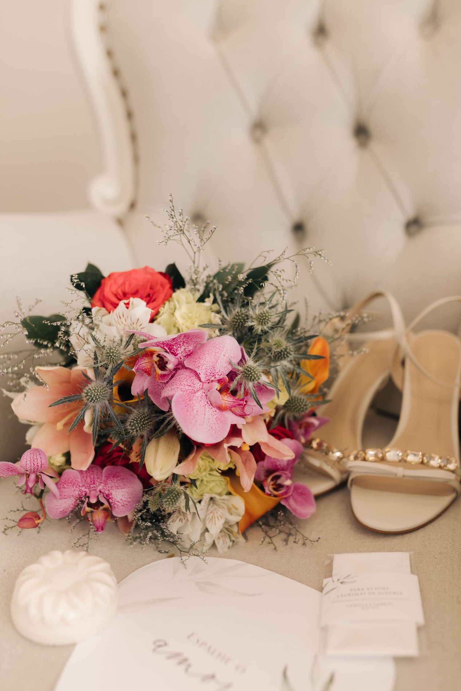 Colorful floral headpiece featuring pink orchids, coral blooms, and dusty gray foliage.