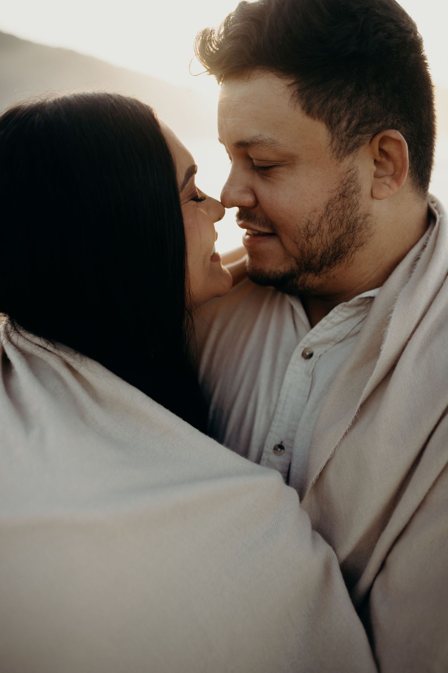 Intimate close-up of couple sharing tender moments on the beach.