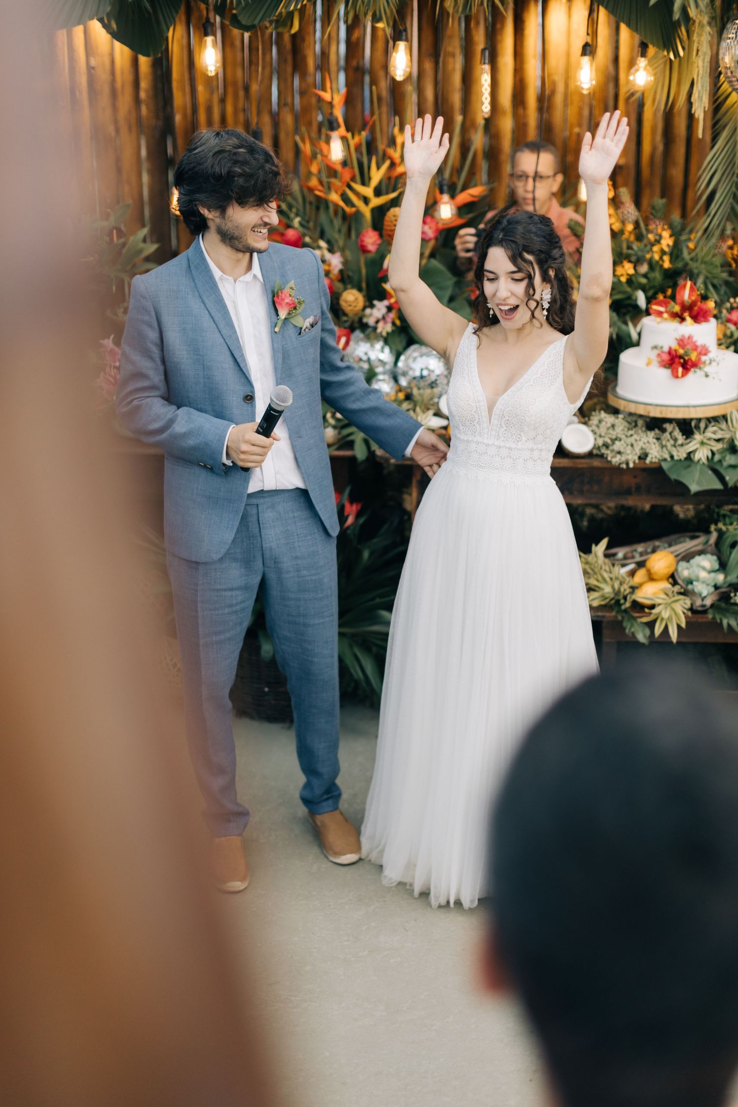 Joyful moment at a wedding with tropical decor and disco balls.