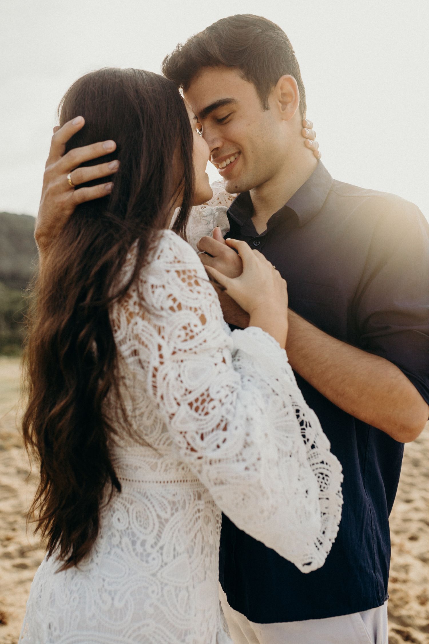 Romantic sequence of a couple in white lace and navy blue sharing tender moments in golden sunlight.