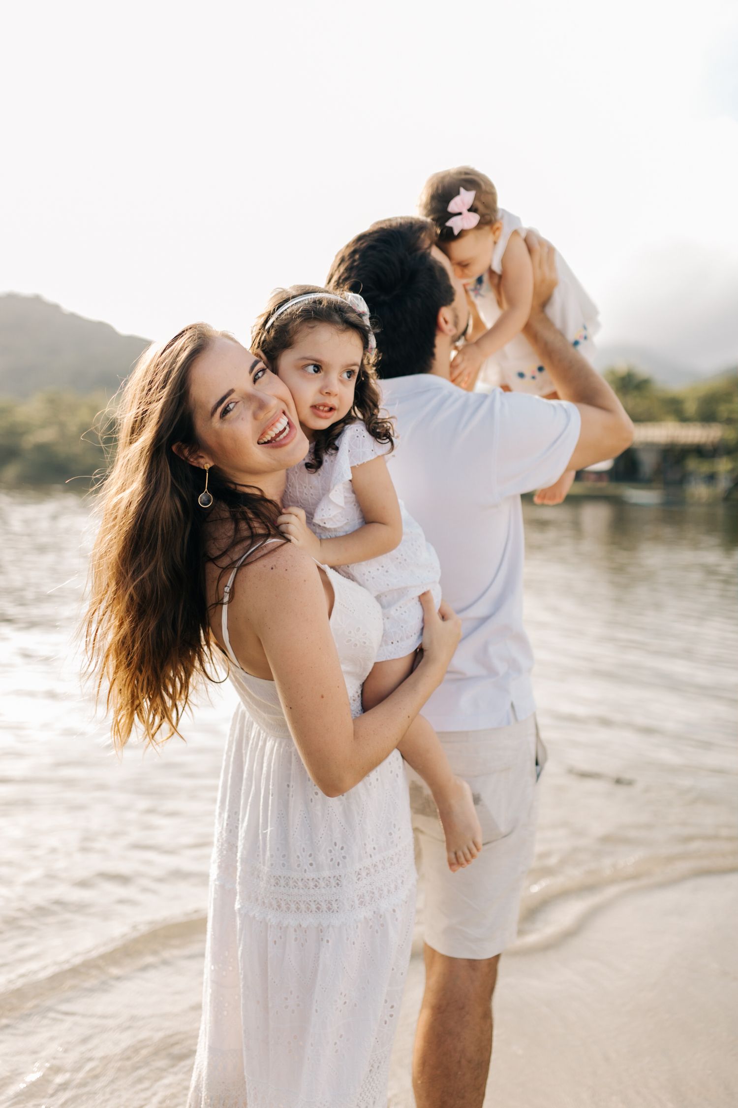 Happy family moment captured at the beach during golden hour.