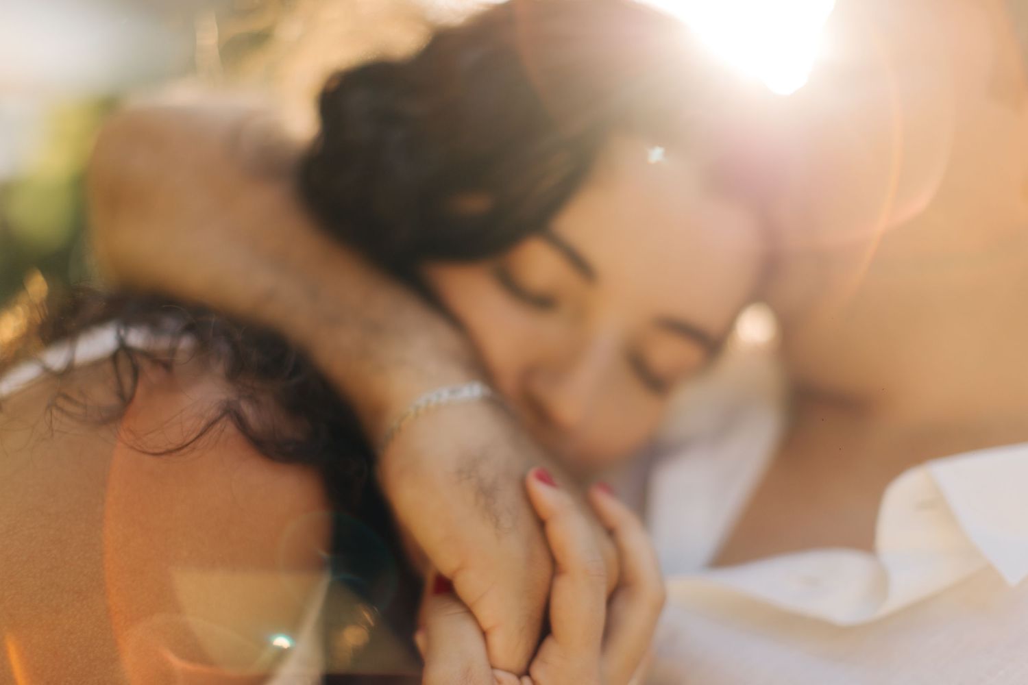Dreamy close-up shot of couple sharing intimate moment in warm sunlight.