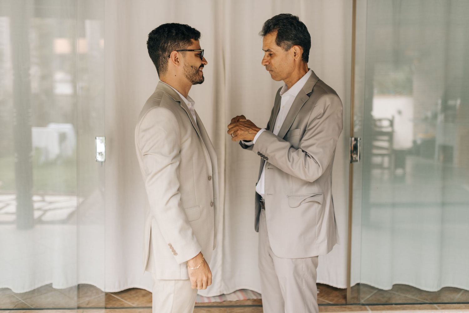 Two people in light suits having conversation in bright room.