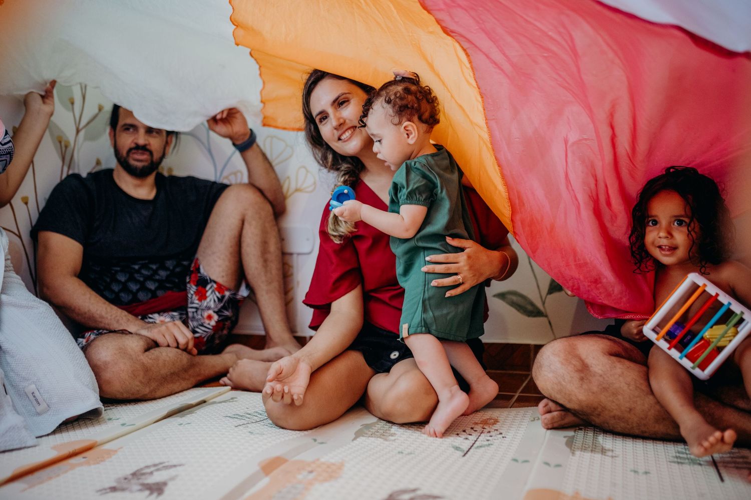 A group gathered on floor cushions with colorful blankets for storytelling or reading time.