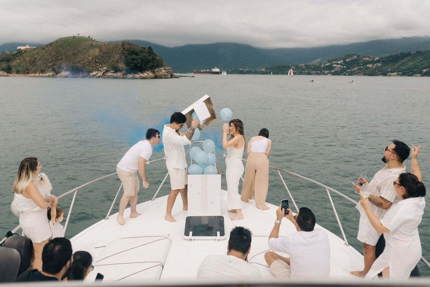 Luxury boat trip with passengers relaxing on deck against mountainous coastline.