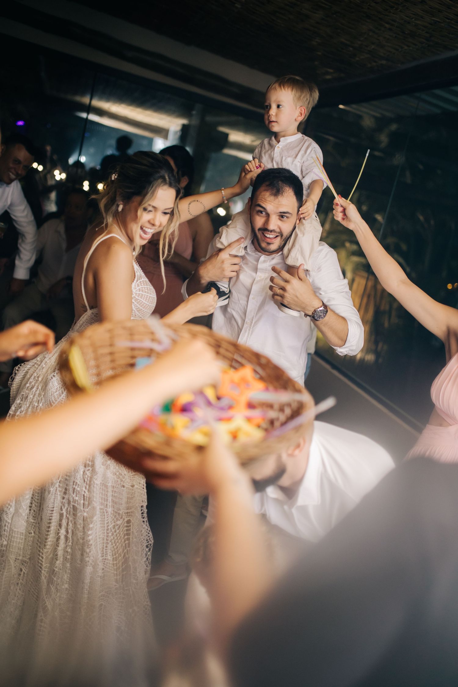 Wedding party members celebrating with sparklers at an indoor reception venue.