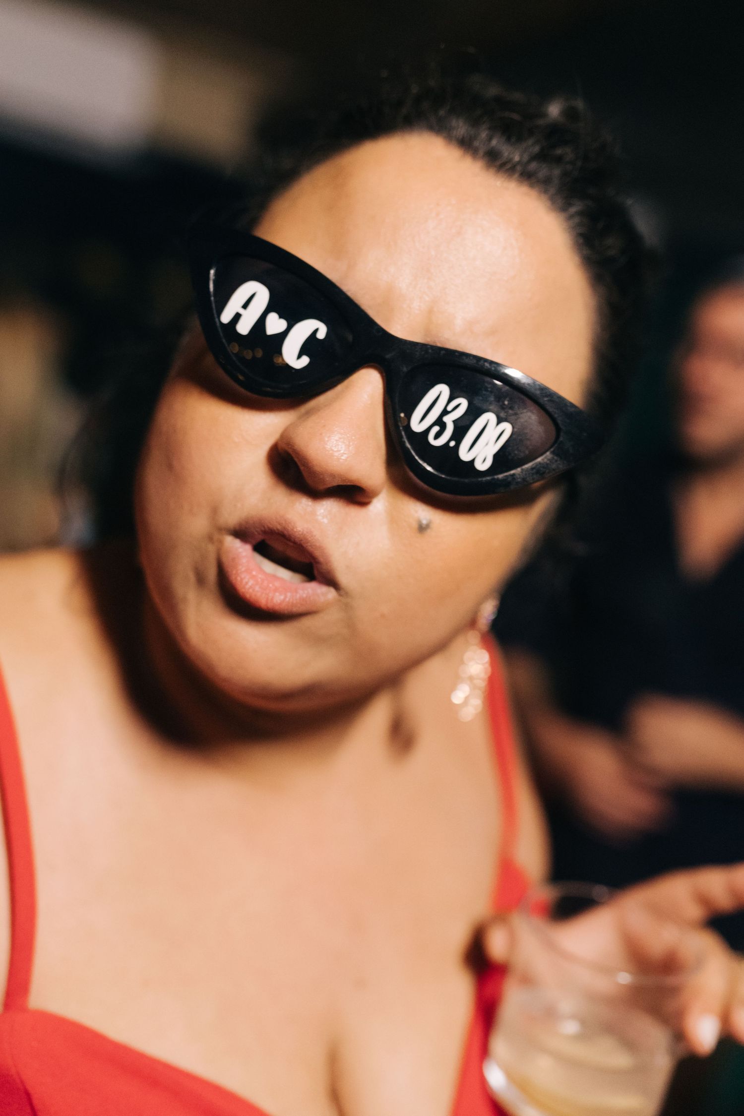 Close-up party shot with festive sunglasses and red attire.