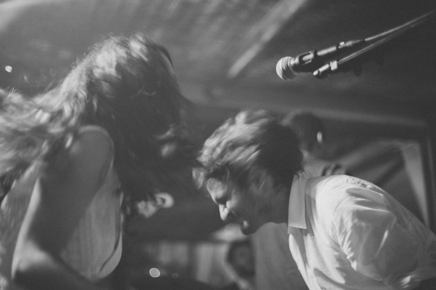 Artistic black and white capture of performers in dynamic motion on stage.
