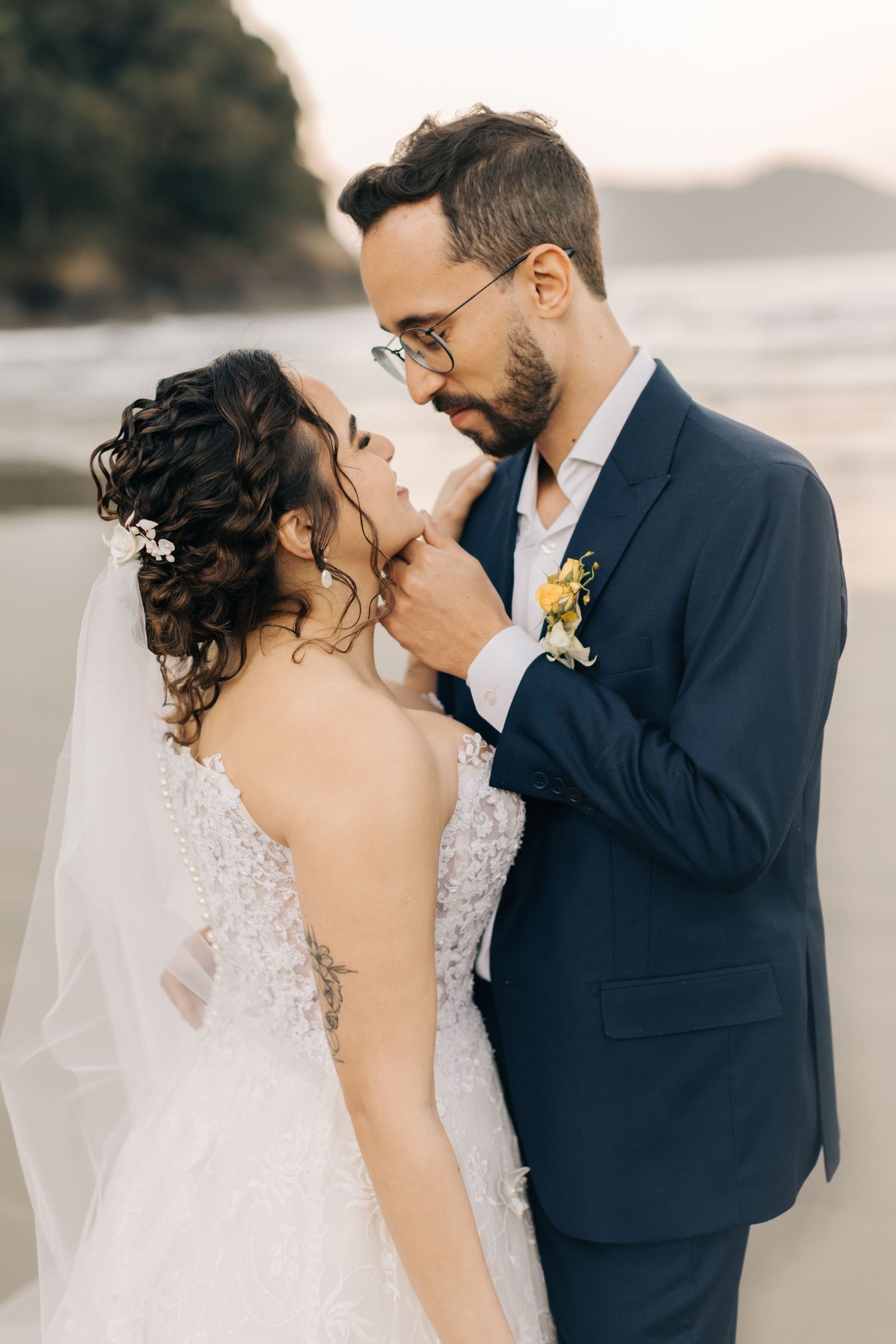 Tender moment captured during a beach wedding photoshoot at sunset.