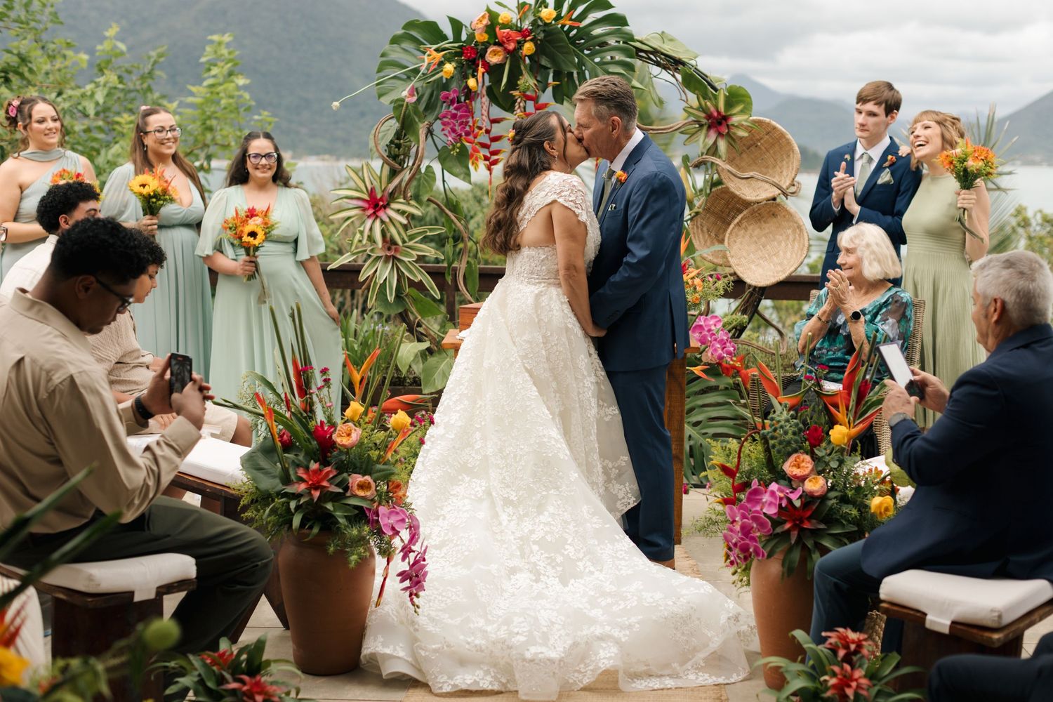 Wedding ceremony setup with tropical flowers and palm trees creating a beautiful outdoor garden atmosphere.