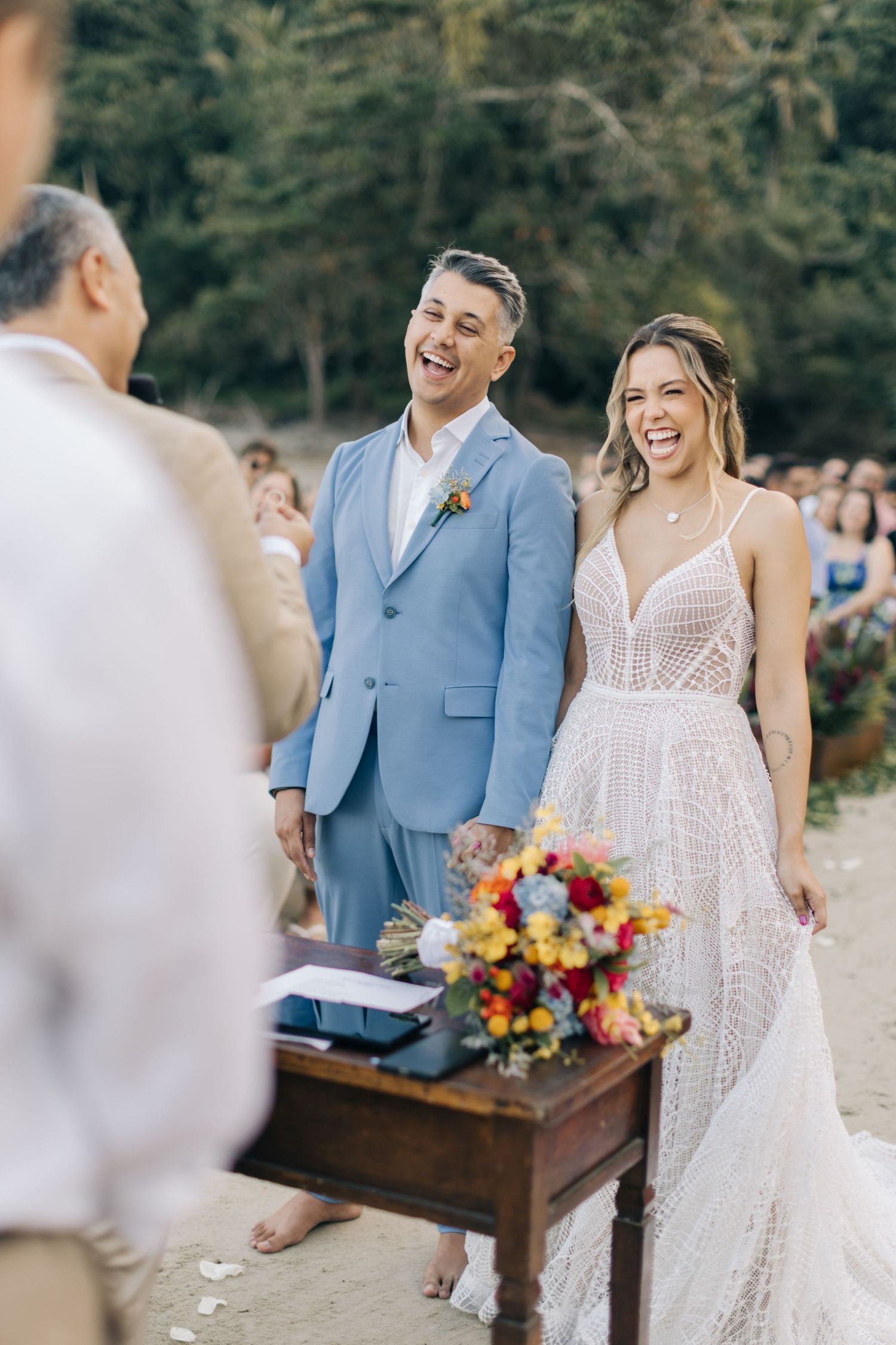 Wedding ceremony in a garden setting with a couple standing at a wooden altar.