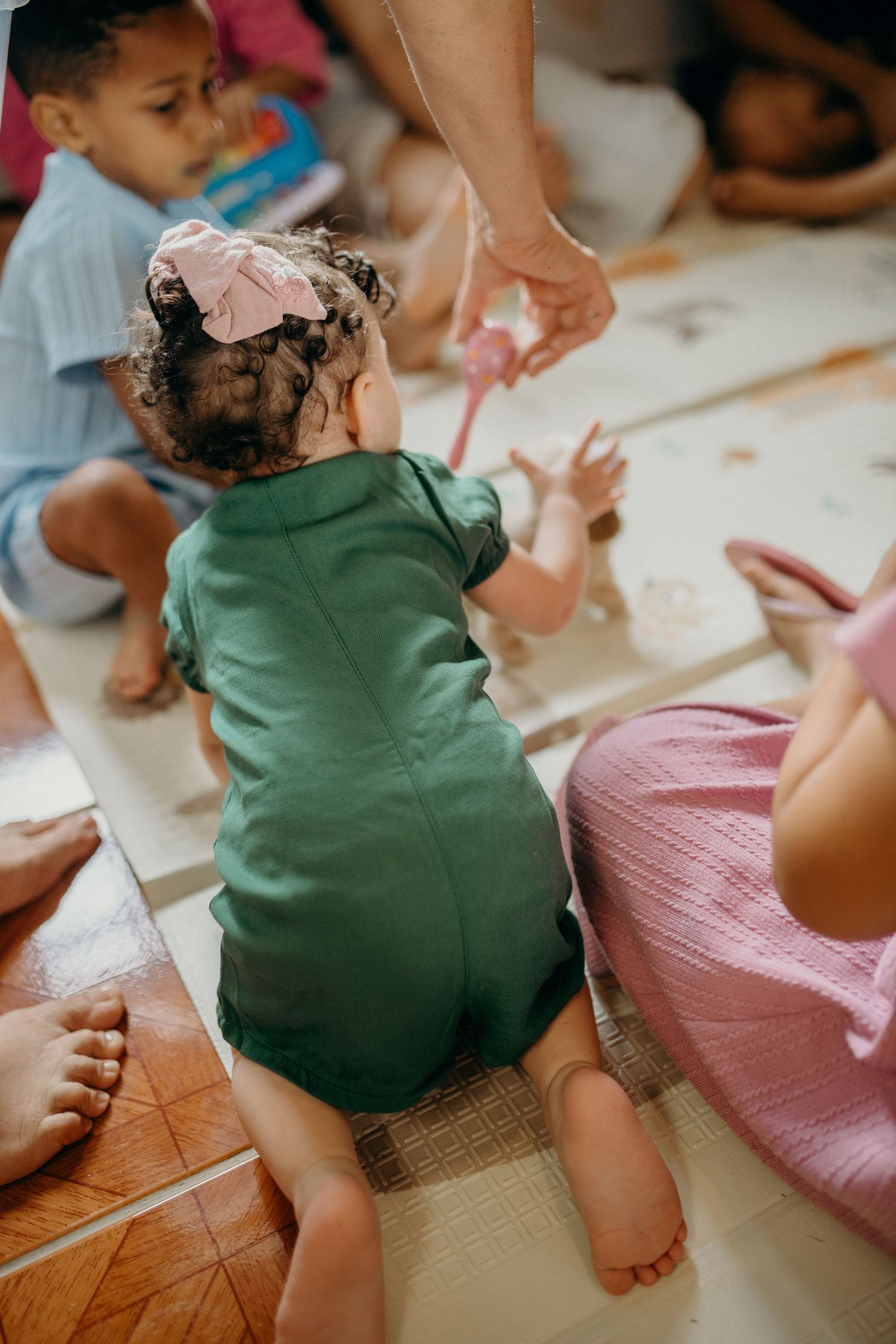 Children playing beneath colorful fabric in a cozy indoor setting.