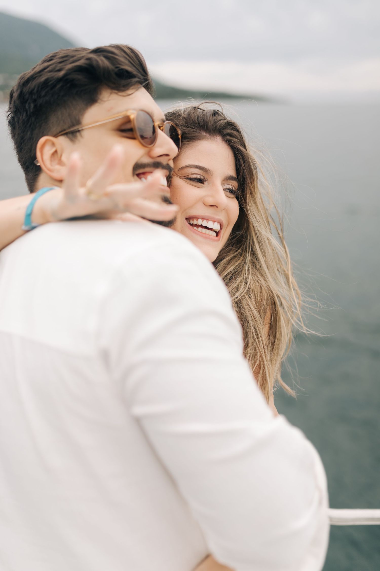 Joyful moment captured on boat with mountain scenery in background.