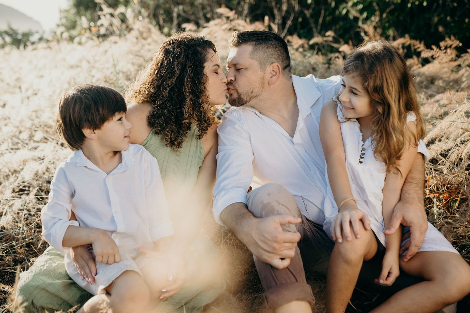 Intimate family portrait showing affectionate moments between loved ones in natural setting.