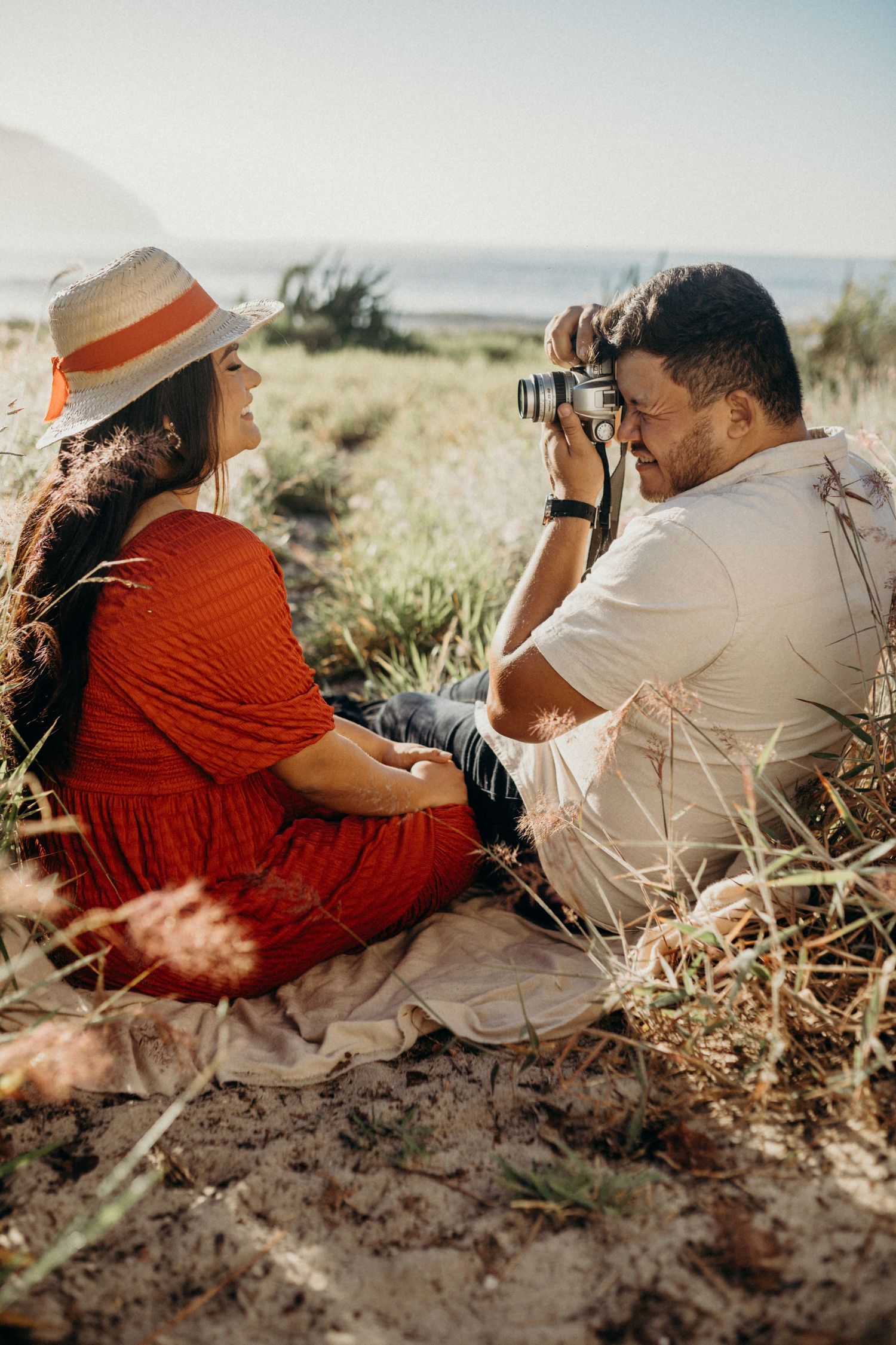 Casual outdoor photography session with vintage camera near ocean view.