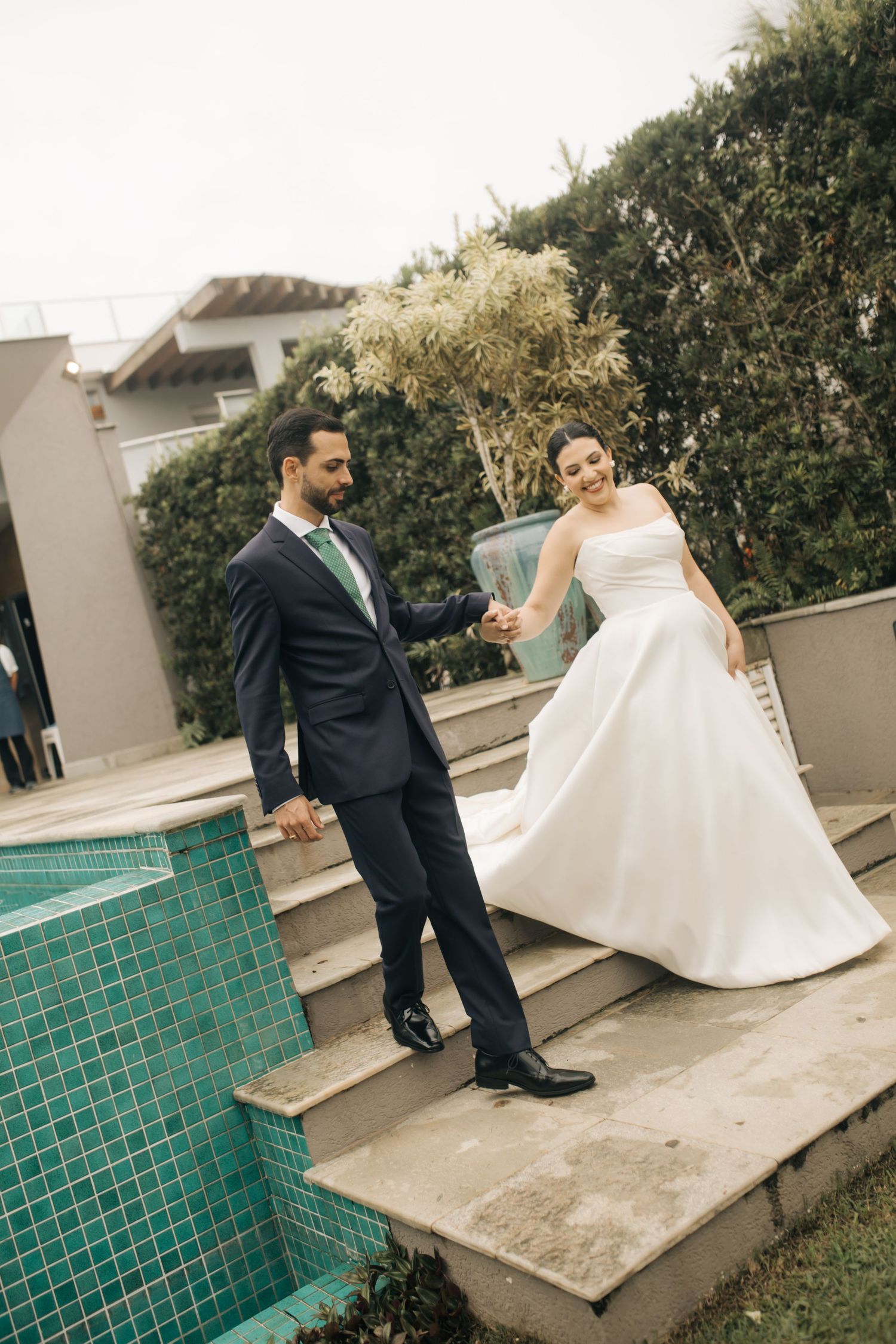 Wedding couple posing by a tiled pool during their special day.