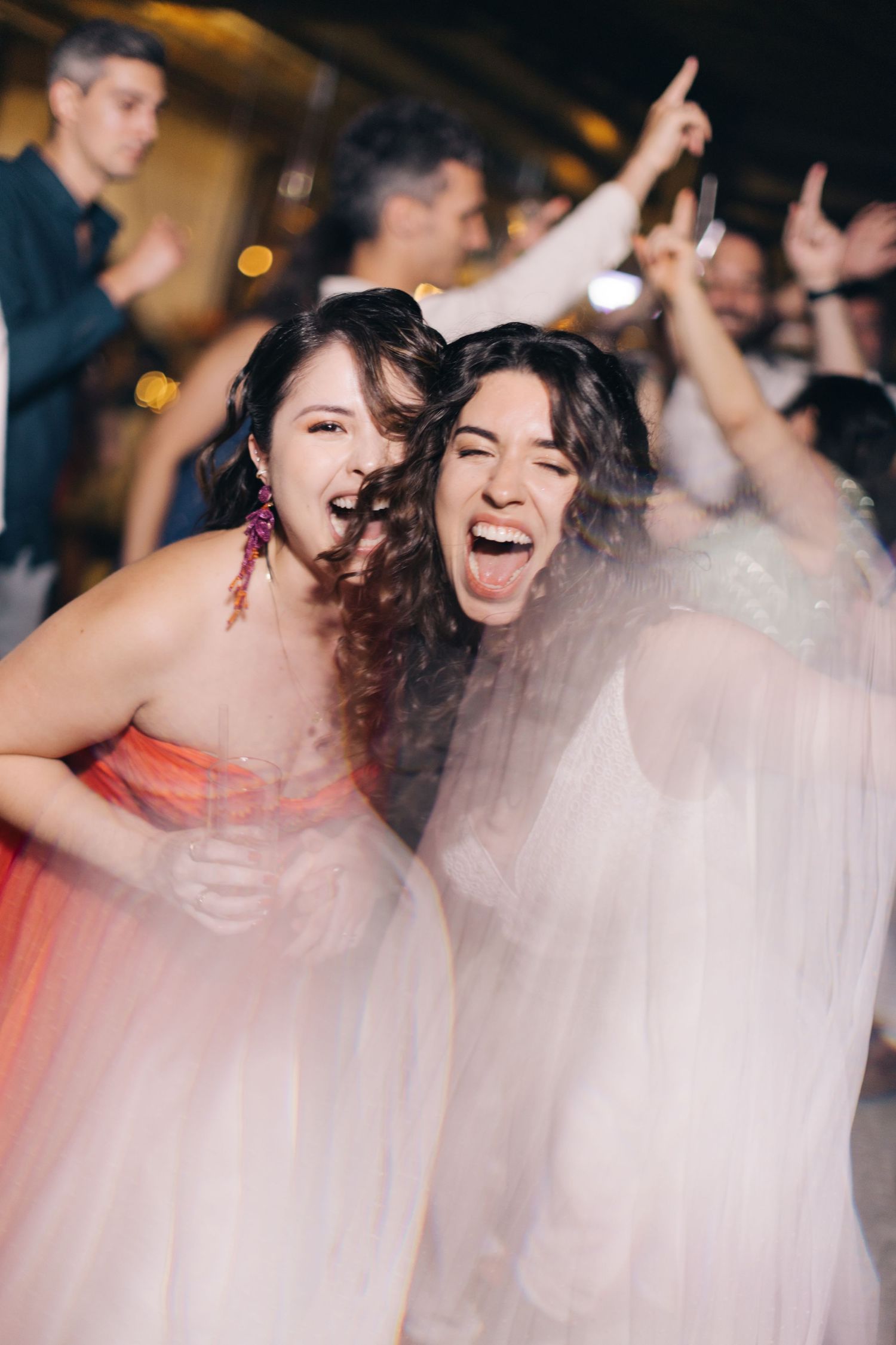 Wedding guests dancing and celebrating with the bride in her flowing white gown.