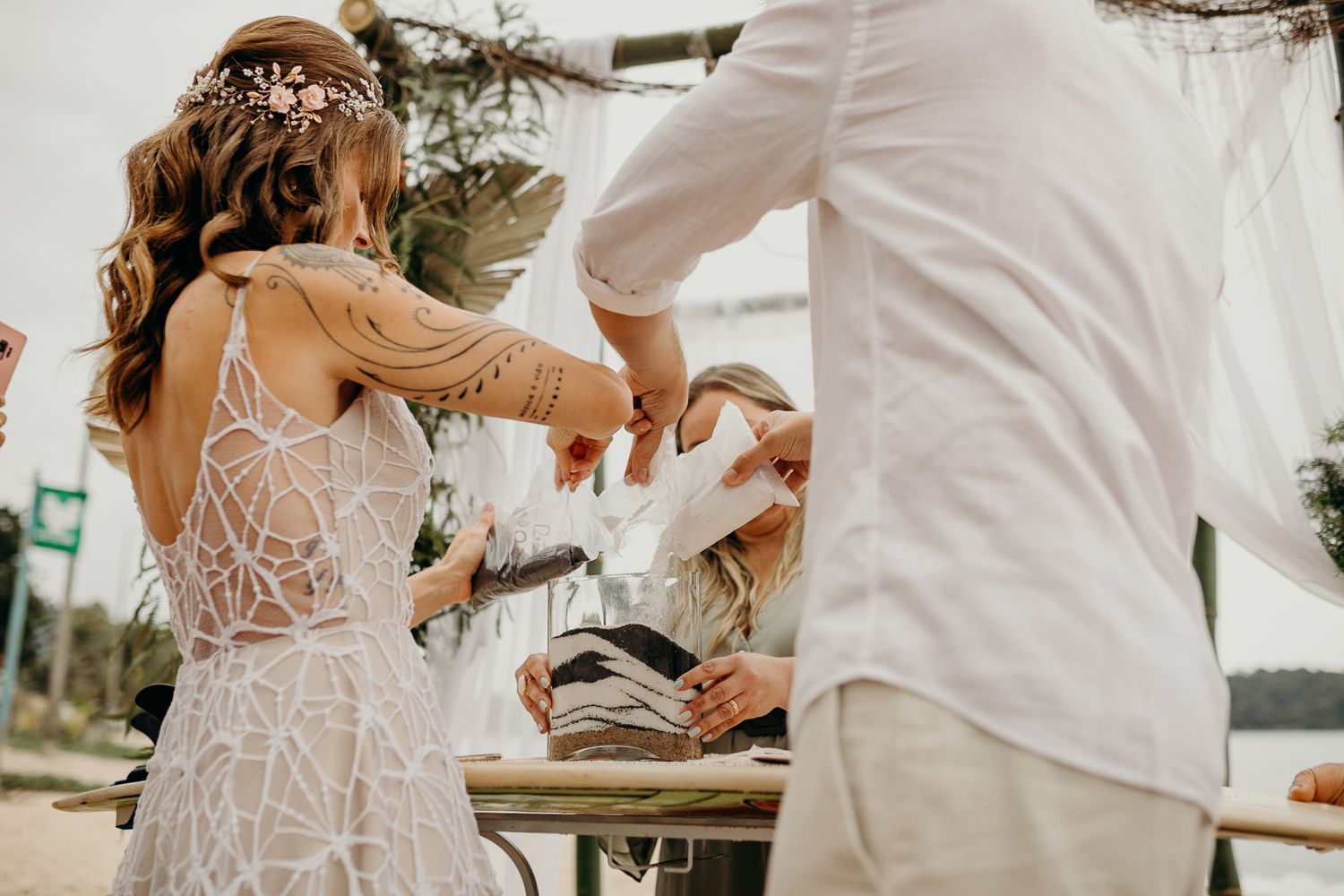 A festive moment during a beach wedding reception with hands raised in celebration.