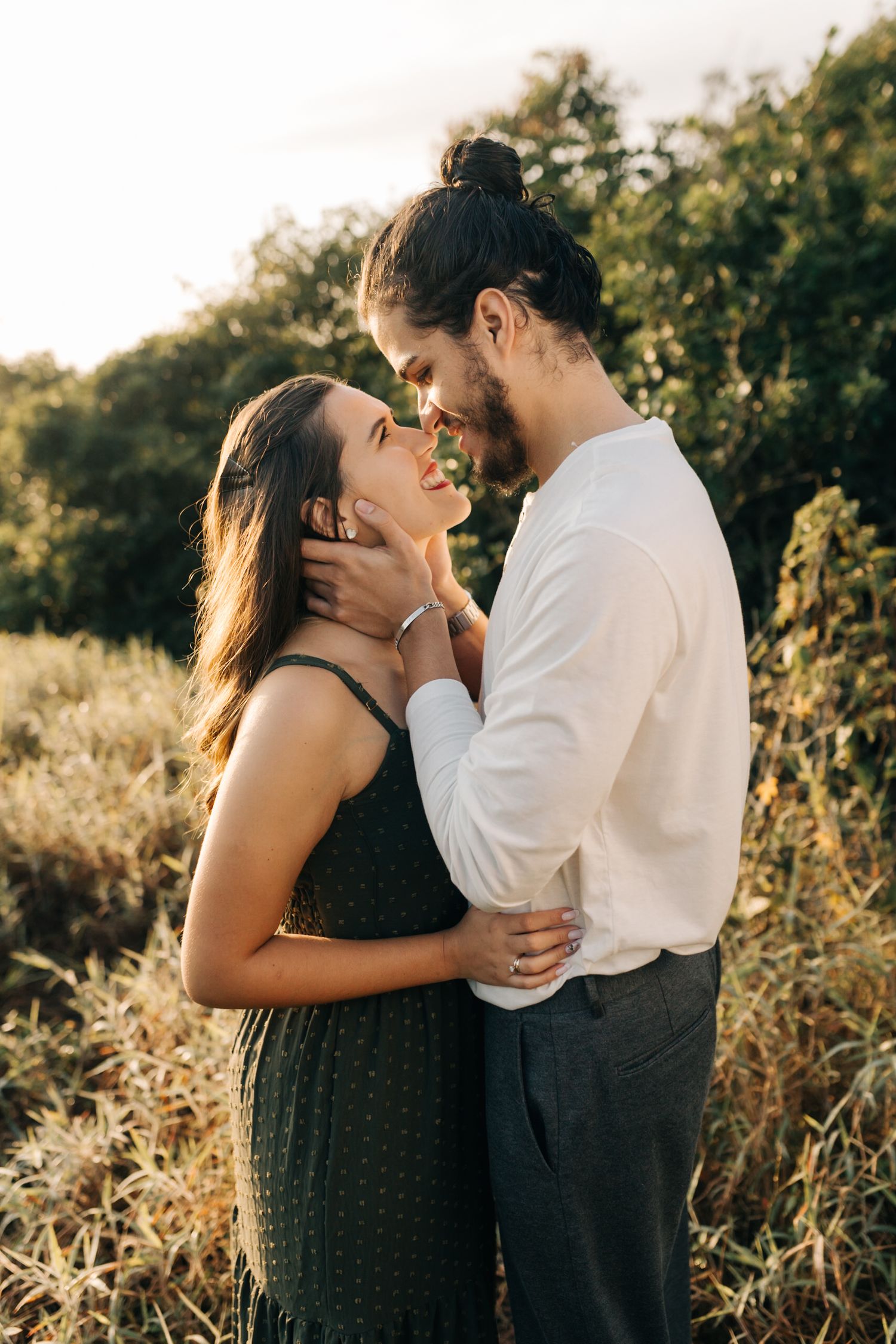 Intimate portrait of couple embracing in golden evening light.