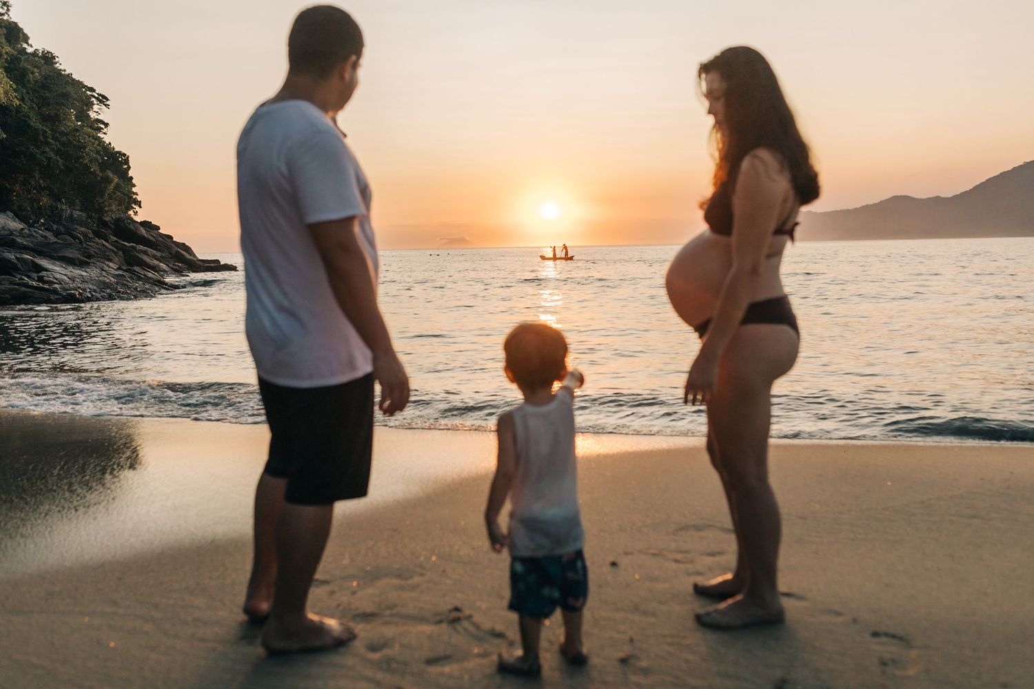 Family spending time together on beach during golden sunset hour.