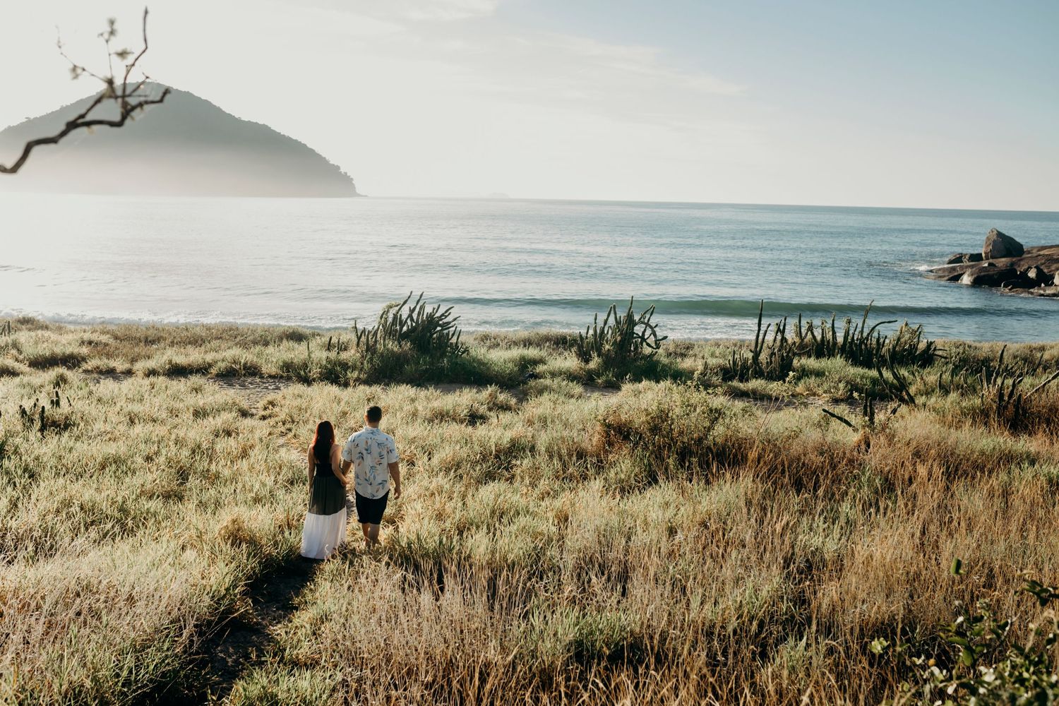 Scenic coastal landscape with mountains and ocean during golden hour.