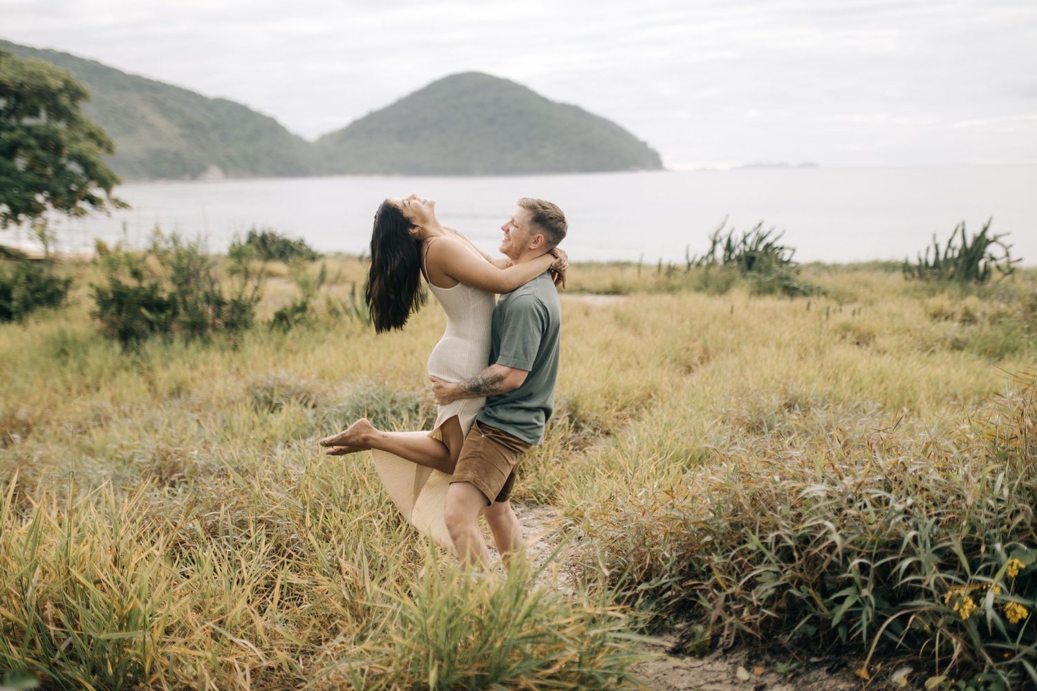 A romantic photoshoot captures intimate moments between a couple in a natural outdoor setting.