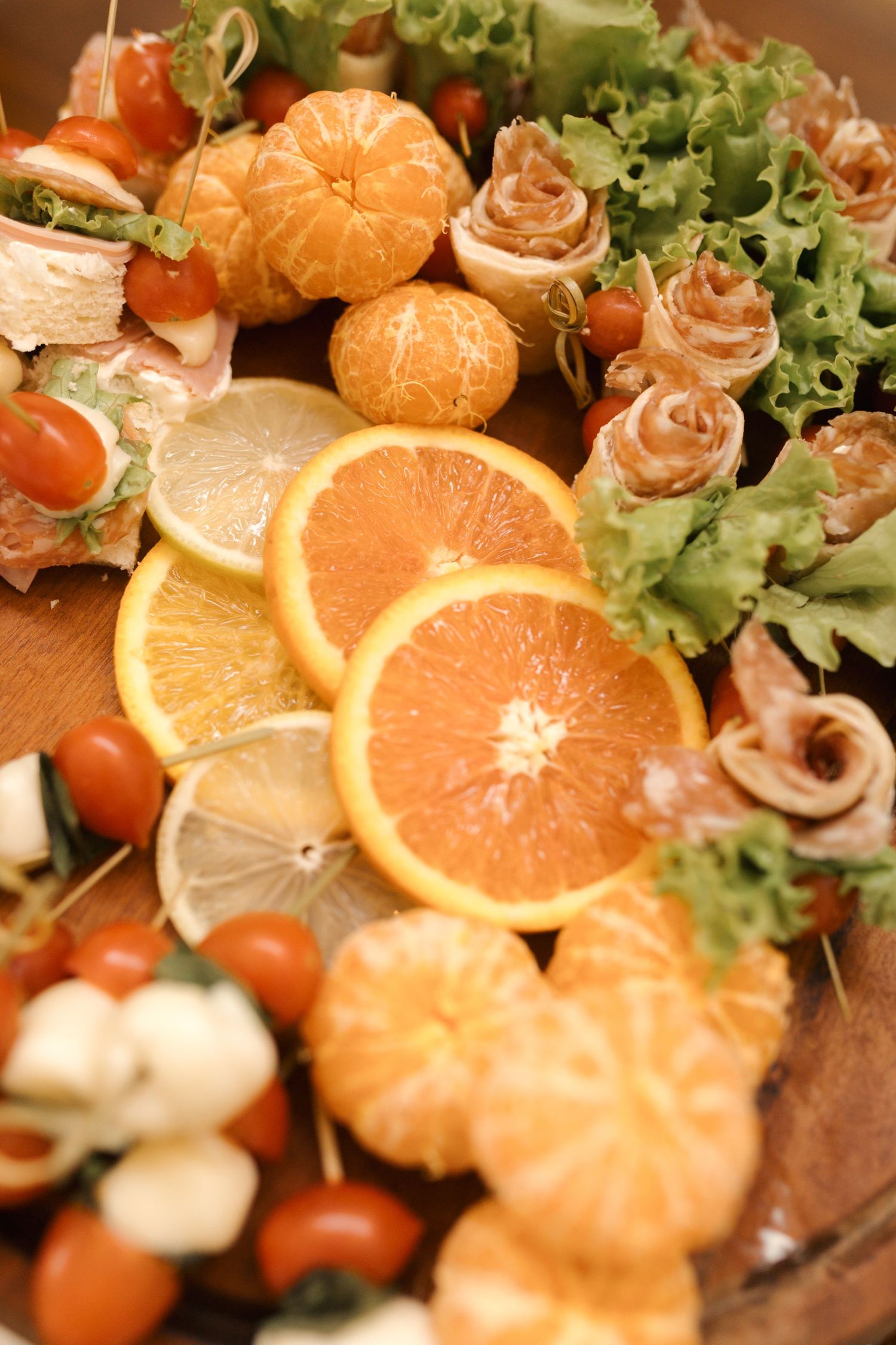 Colorful appetizer platter with citrus slices, cherry tomatoes and lettuce garnish.