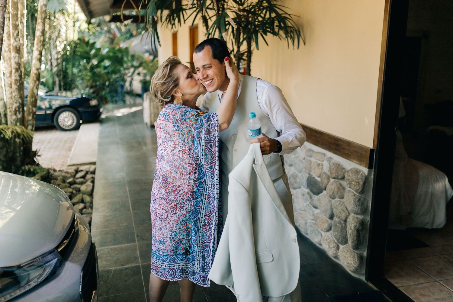 Two people share a joyful moment outside a building.