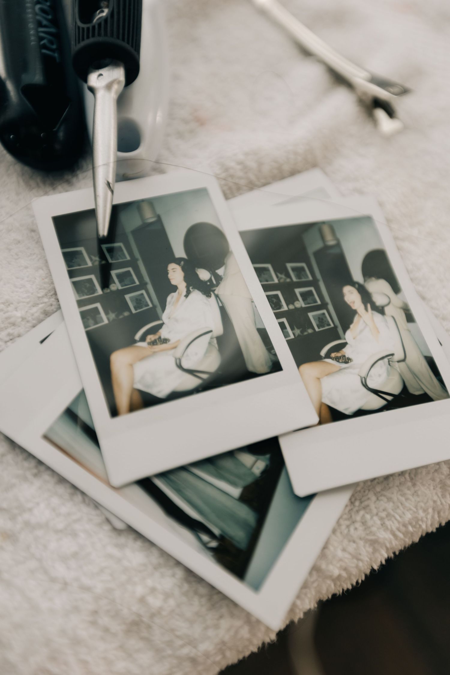 Collection of black and white polaroid photos scattered on a light surface.