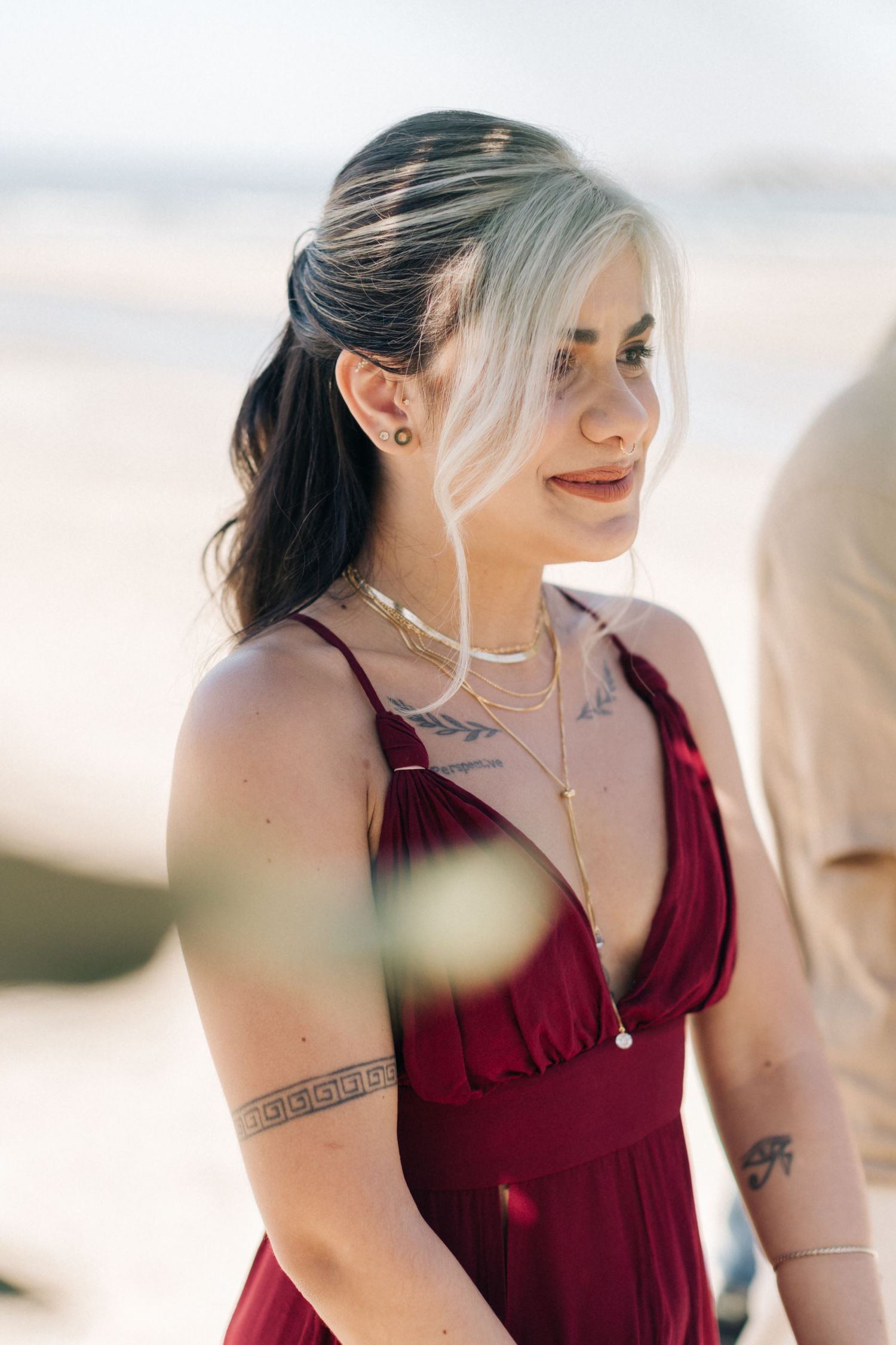Guest in deep red dress at outdoor wedding celebration.