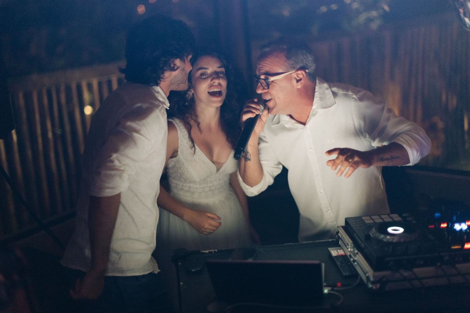 Group of people dancing and laughing at a lively nighttime celebration.