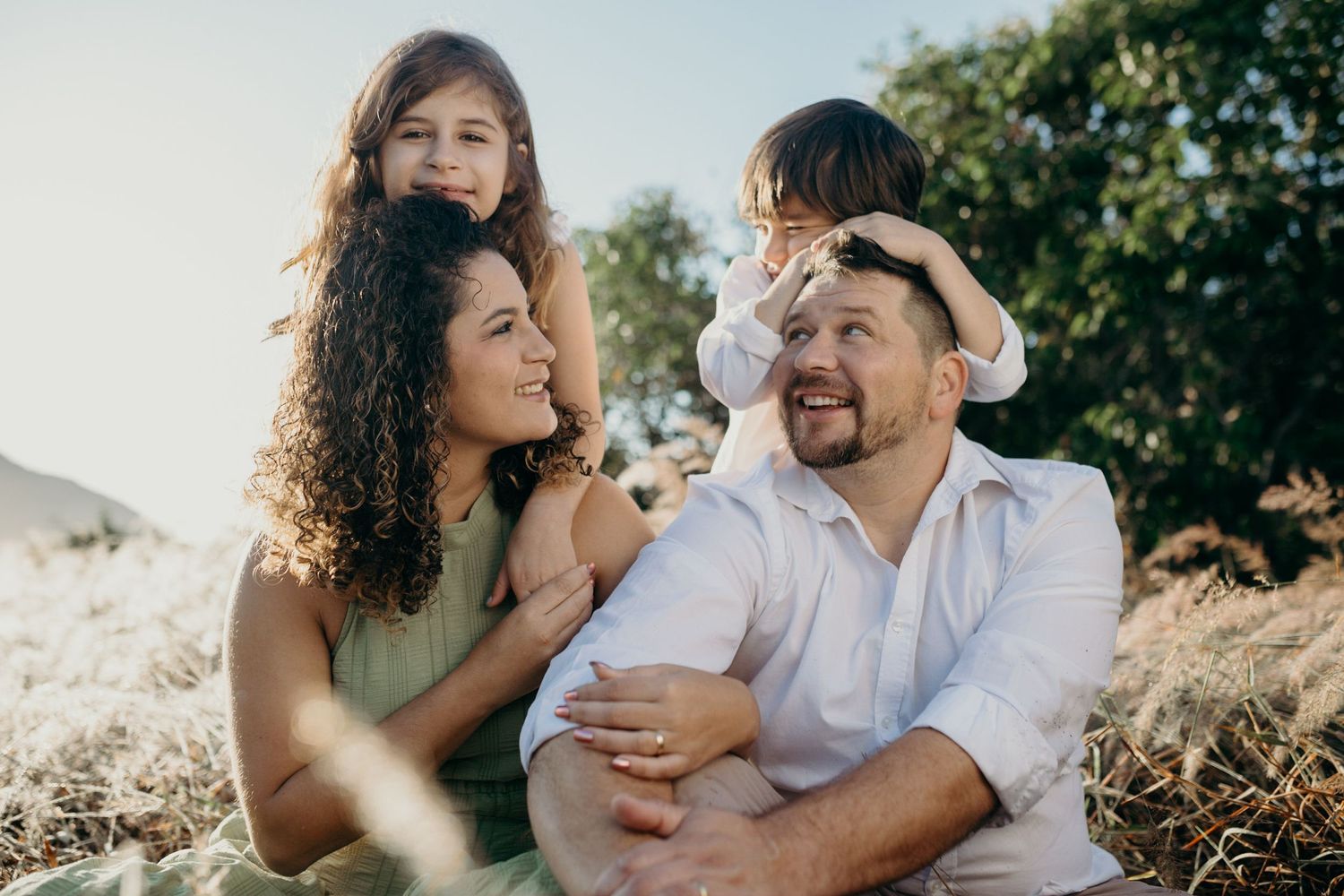A couple smiles and laughs together during an outdoor photoshoot.