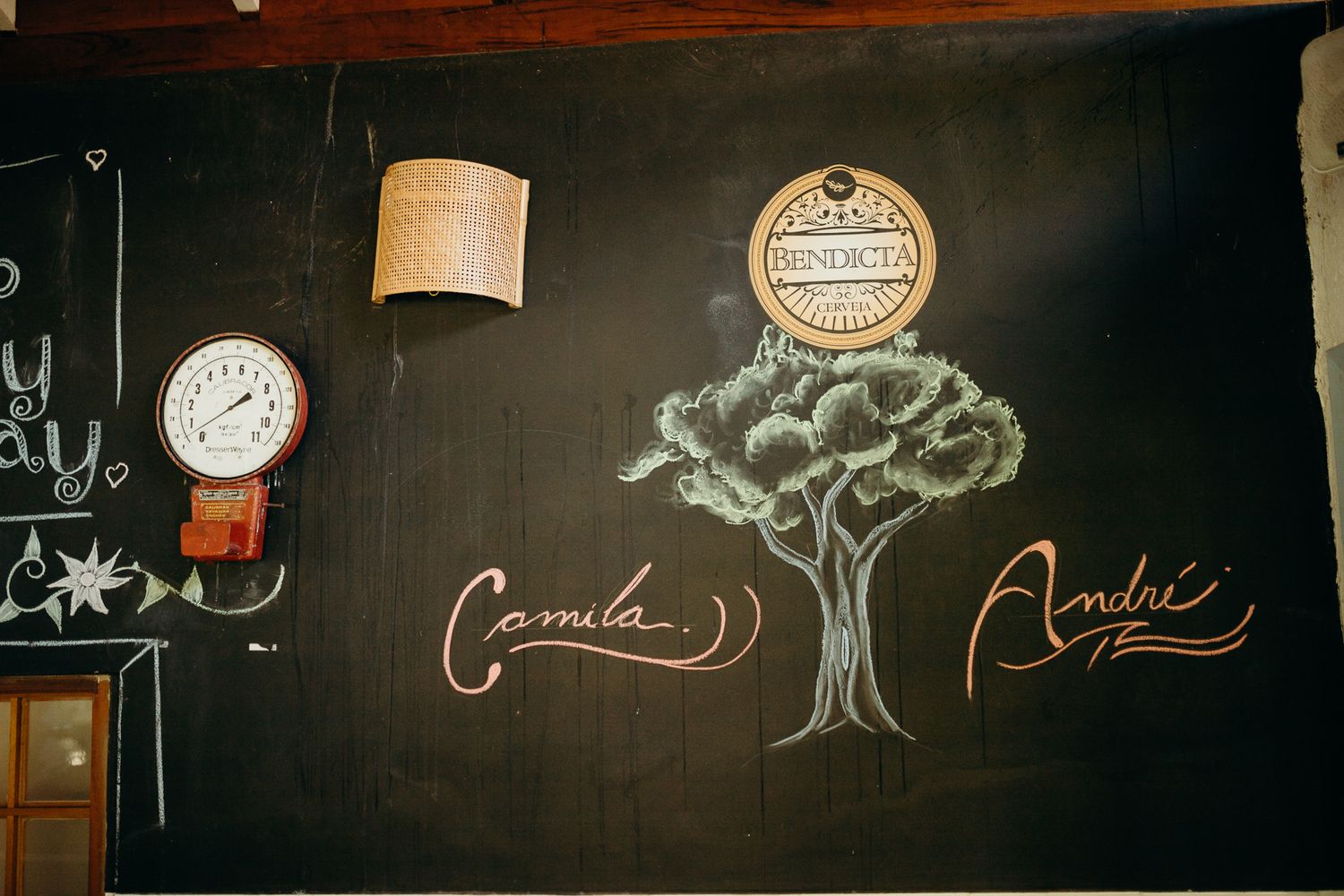 A chalkboard wall featuring artistic drawings and text with pendant lights hanging above.