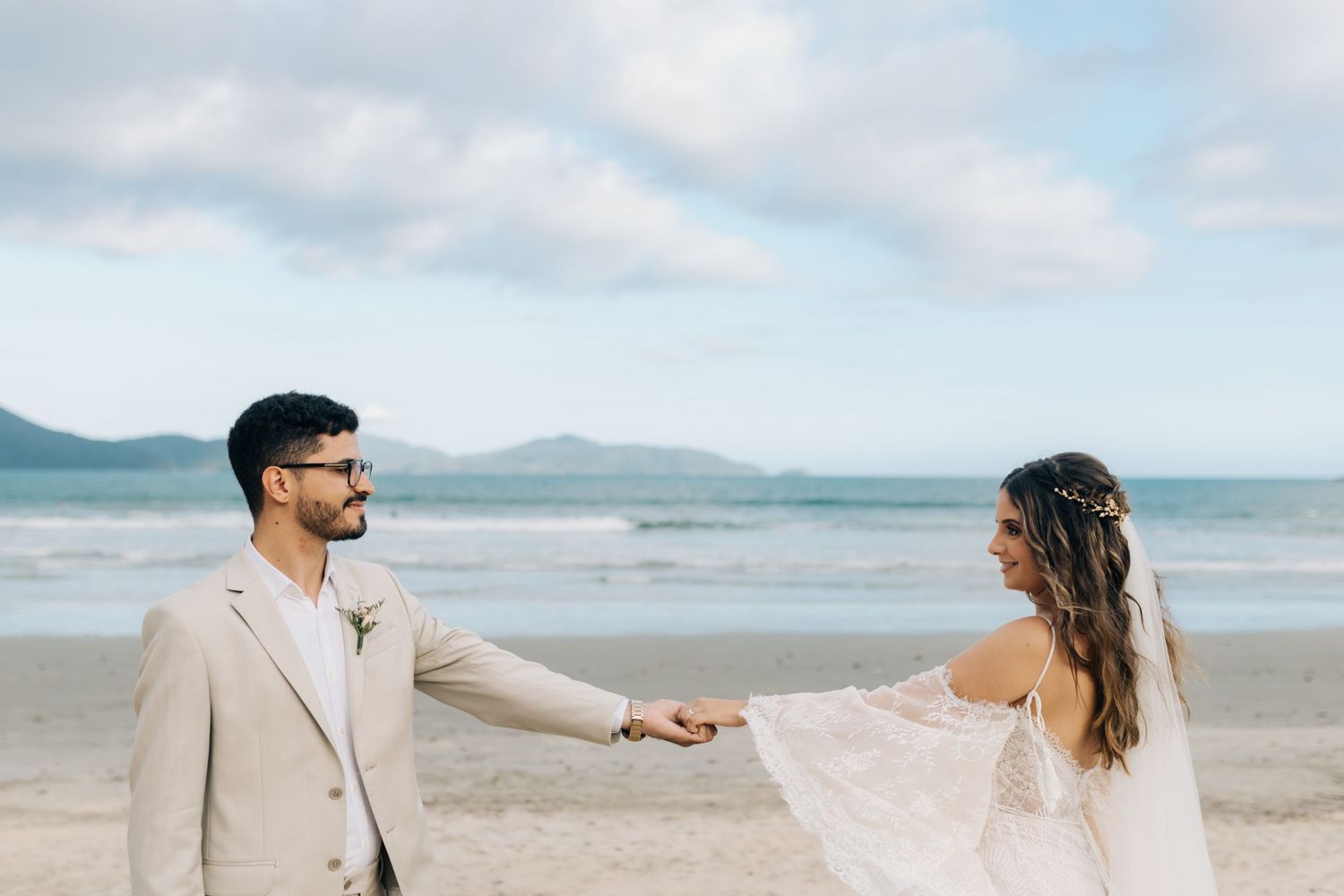 Couple shares playful moment during beach wedding photoshoot.