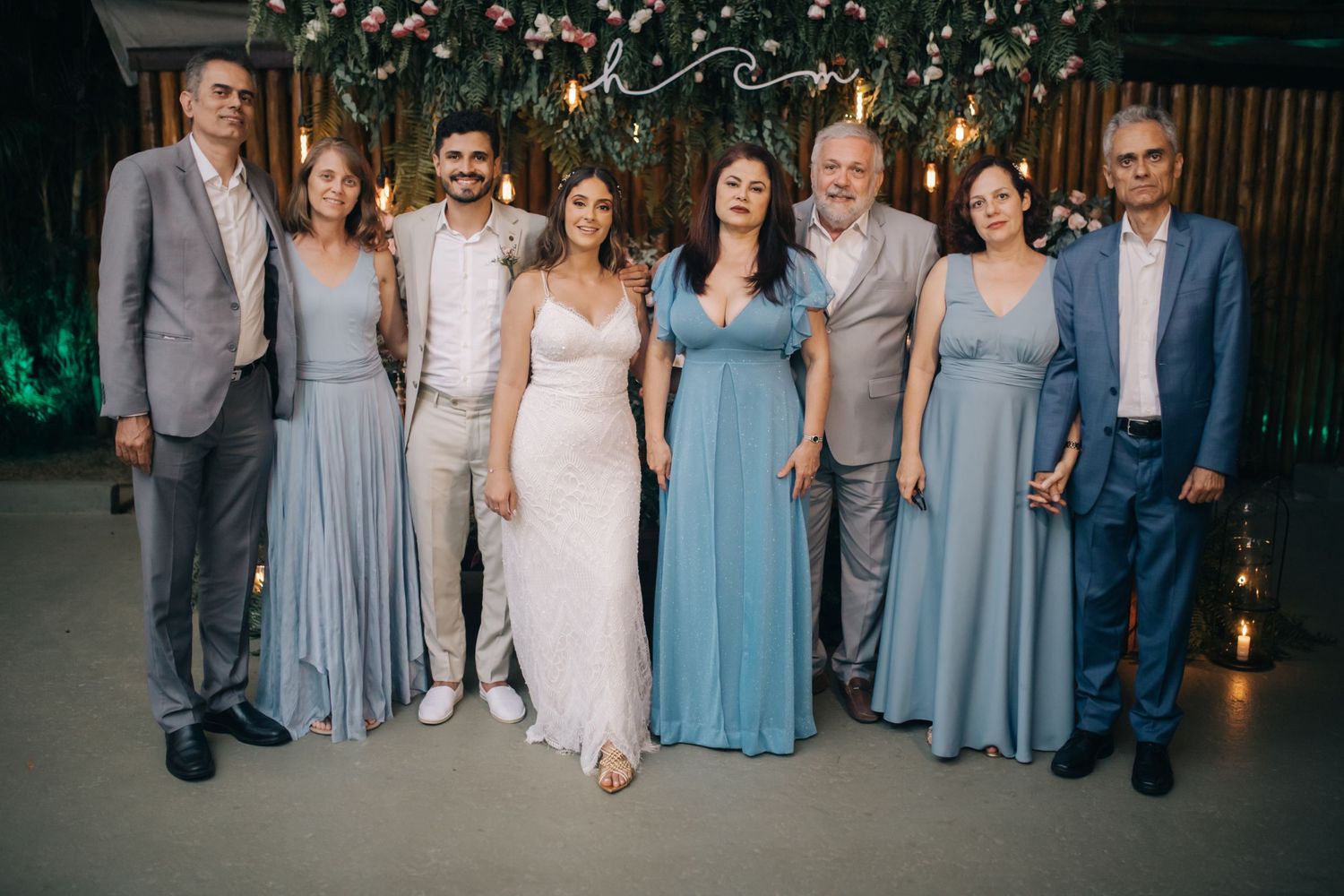 Wedding group portrait with party members in coordinating blue and grey formal attire.