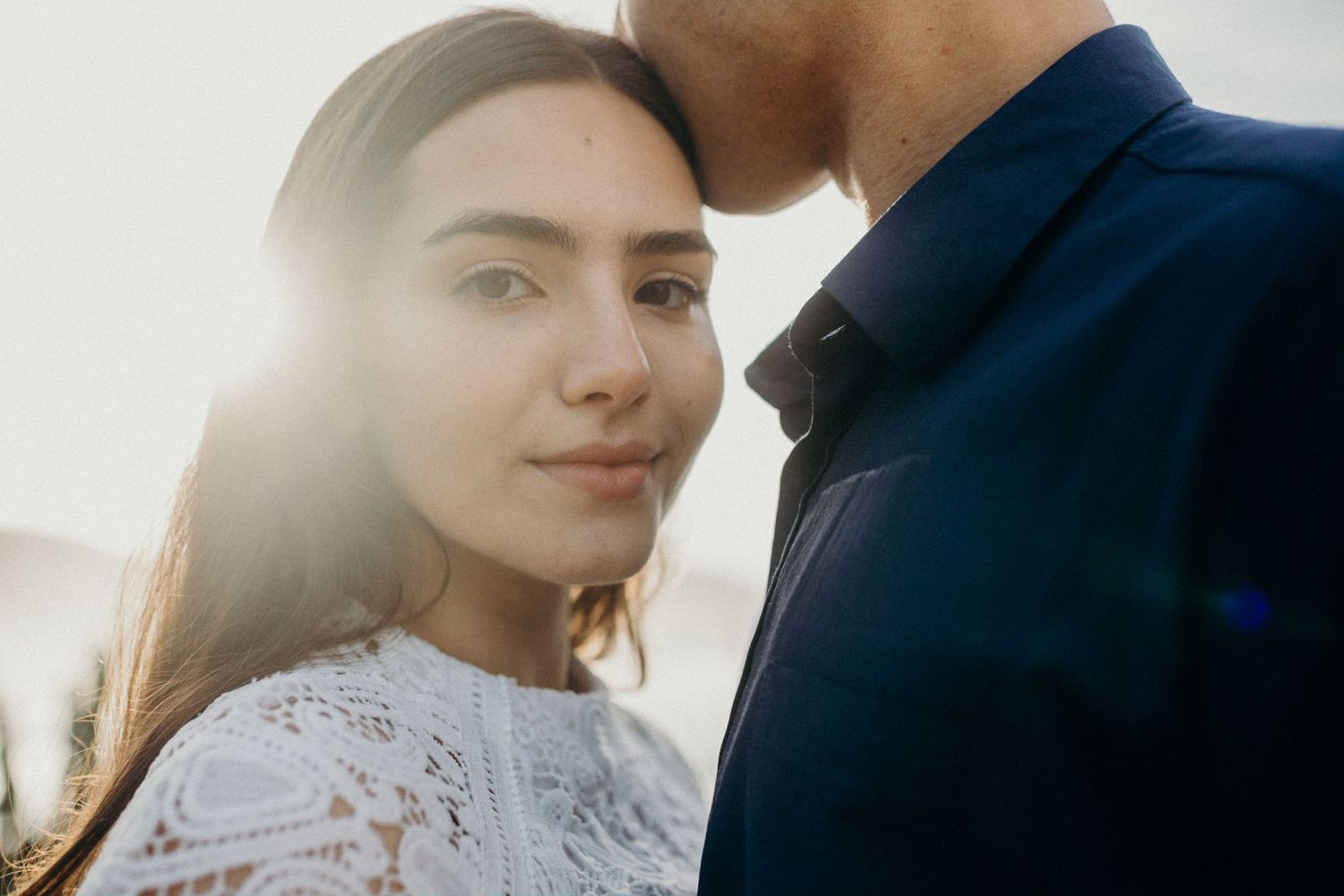 A tender moment backlit by golden sunlight outdoors.