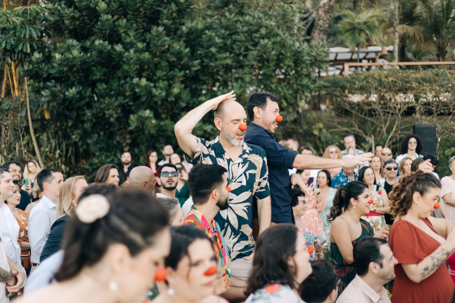 Wedding guests celebrate with enthusiasm during an outdoor reception.