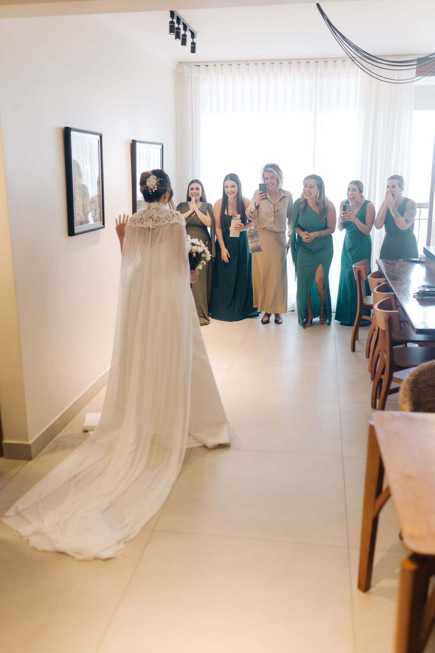 Wedding dress on display with people reacting emotionally in background.