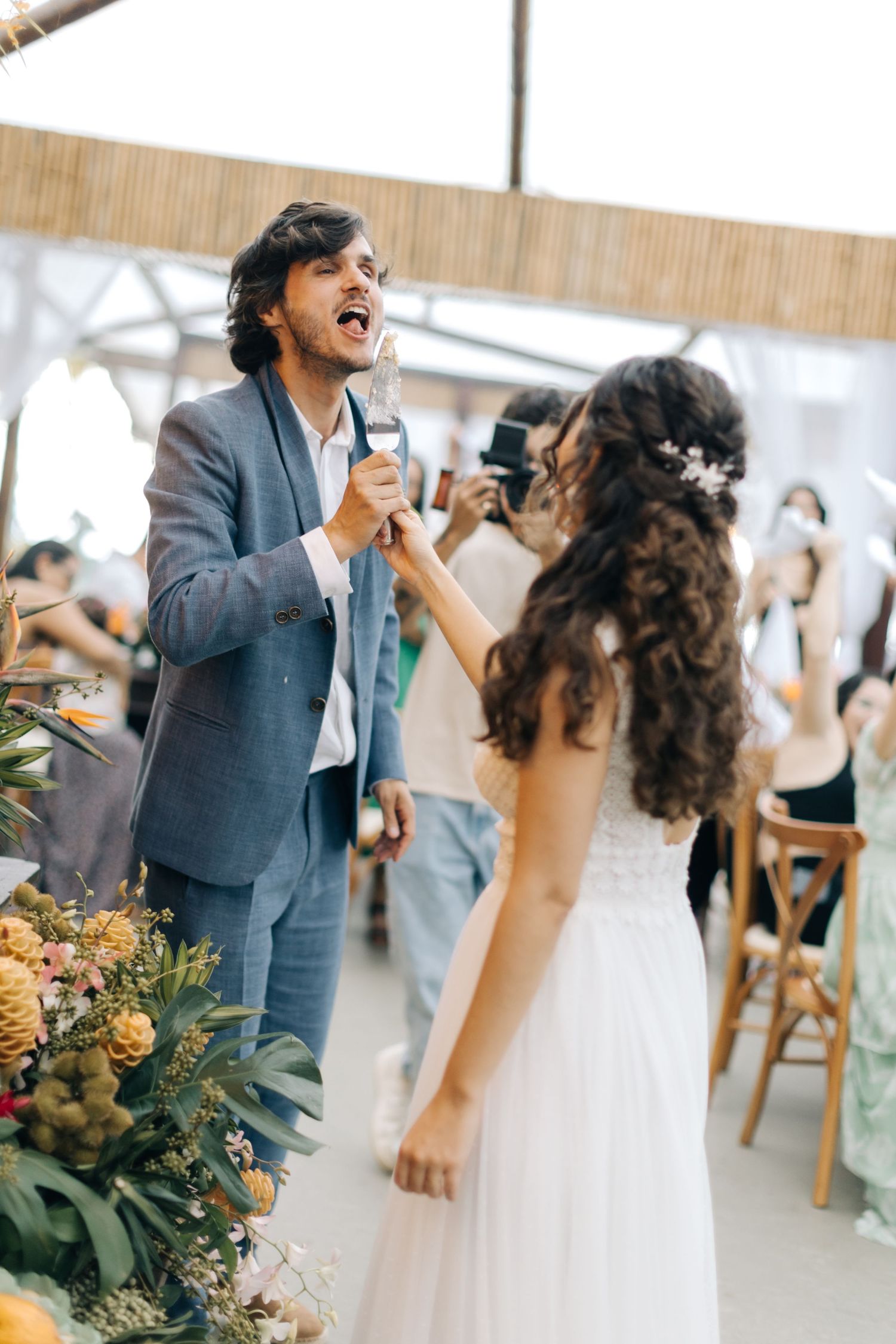 Joyful celebration moment at a wedding with tropical decor and floral arrangements.