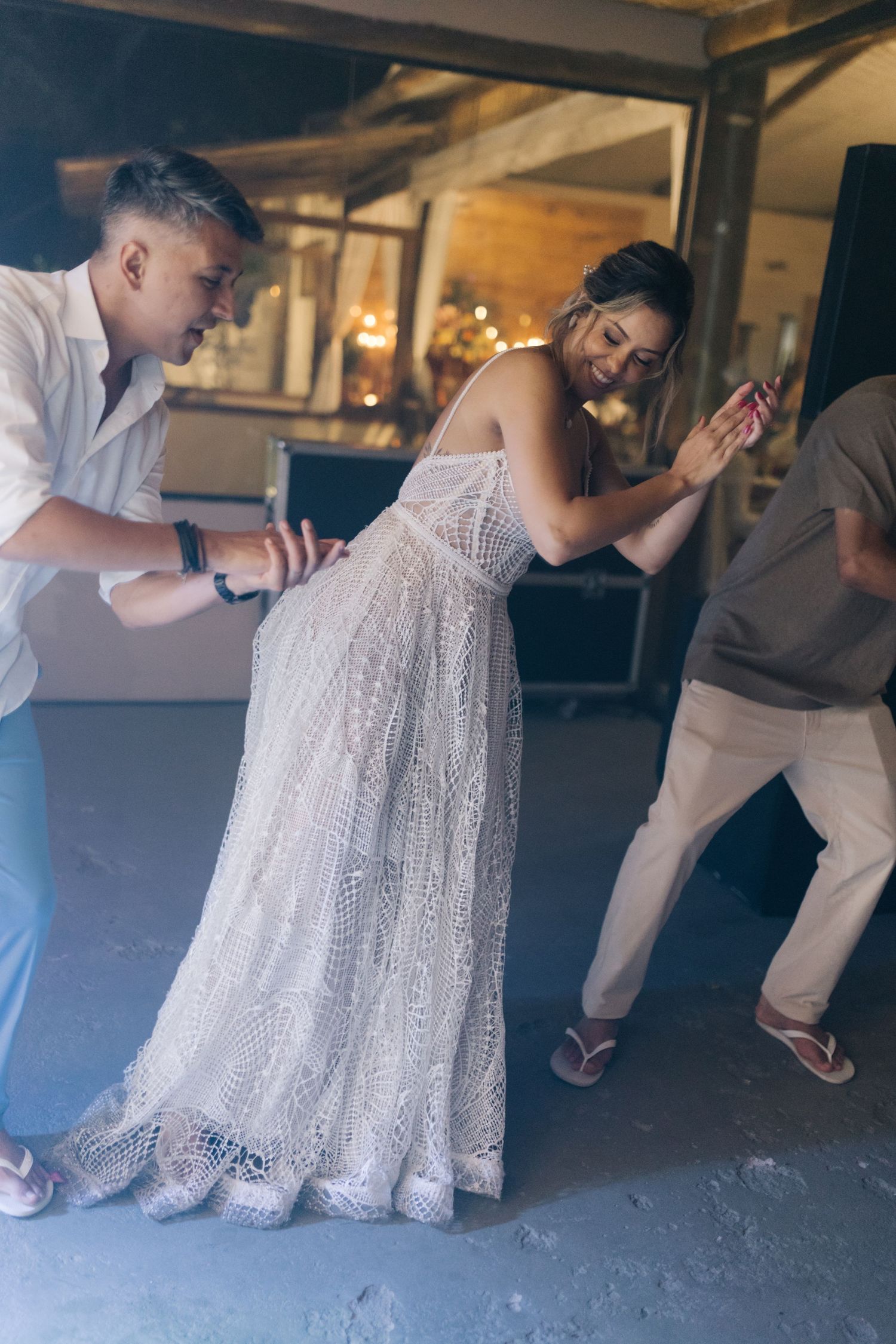 Wedding celebration on the dance floor with bride in detailed white gown.
