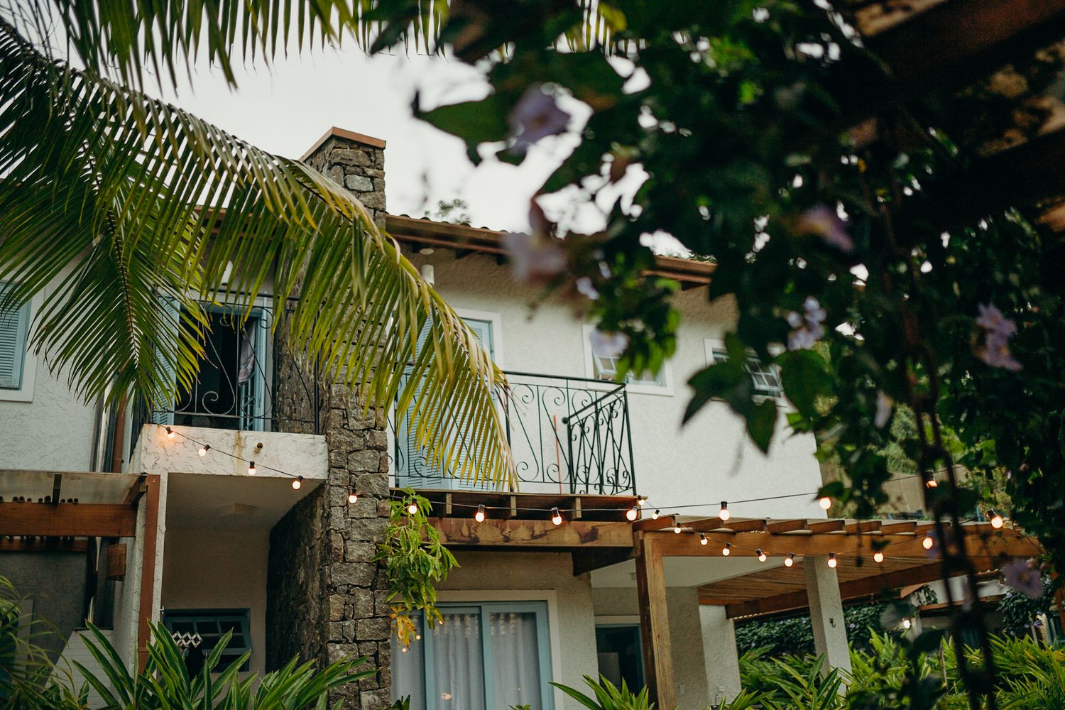 Close-up view of resort balconies with wrought iron railings and palm fronds in foreground.