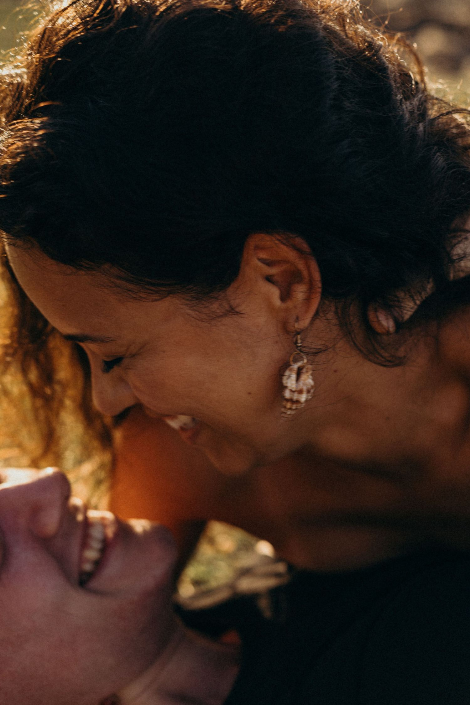 Close-up portrait of joyful moment between couple in golden sunlight.